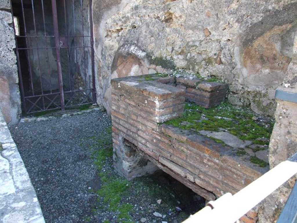 VI.10.1 Pompeii. March 2009.  South wall of caupona with hearth and doorway to rear room on south side. According to Eschebach, the stairs to the upper floor would have been against this south wall. Where the modern gate has been fitted, there may be a mark showing the steps leading up the wall.
