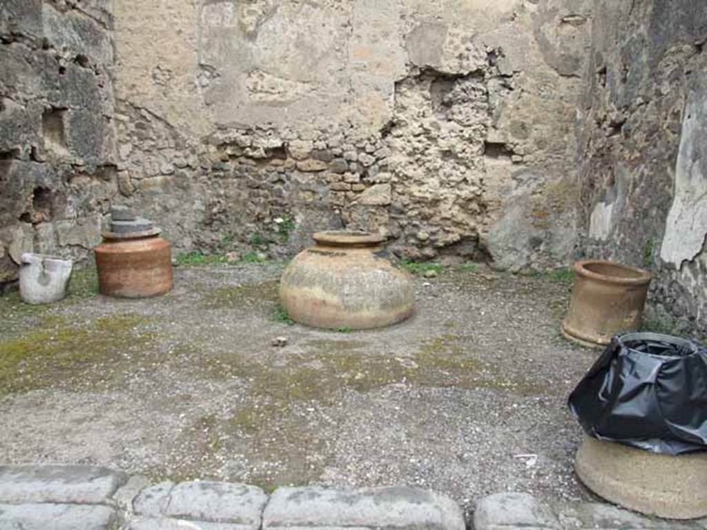 VI.10.10 Pompeii. May 2010. Urn, embedded dolium, terracotta puteal, and modern rubbish-bin .