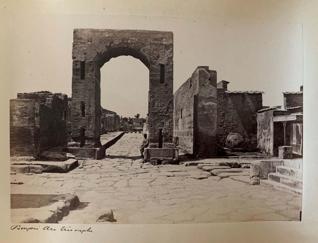 Arch at the south end of Via Mercurio, between VI.8 and VI.10. Looking north.
VI.10.11 Pompeii, entrance doorway, can be seen on the right behind the steps to the Temple of Fortuna Augusta.
From an album dated April 1878. Photograph by M. Amodio. Photo courtesy of Rick Bauer.
