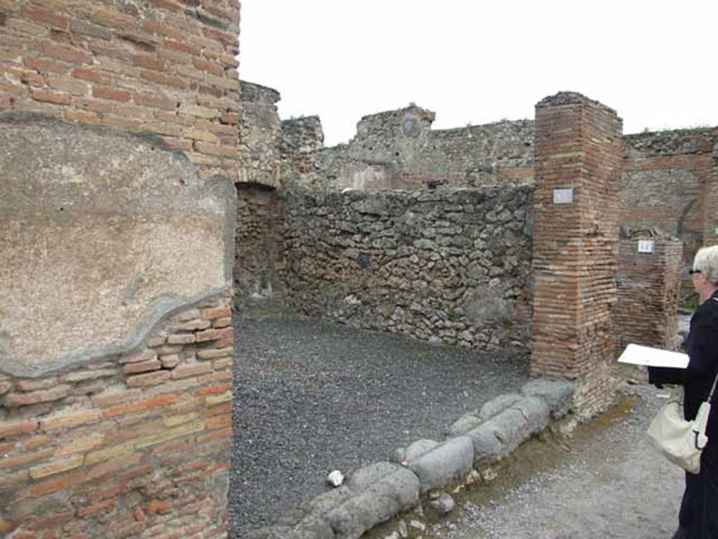 VI.10.13 Pompeii. May 2010. East wall of shop, and threshold onto Via della Fortuna.