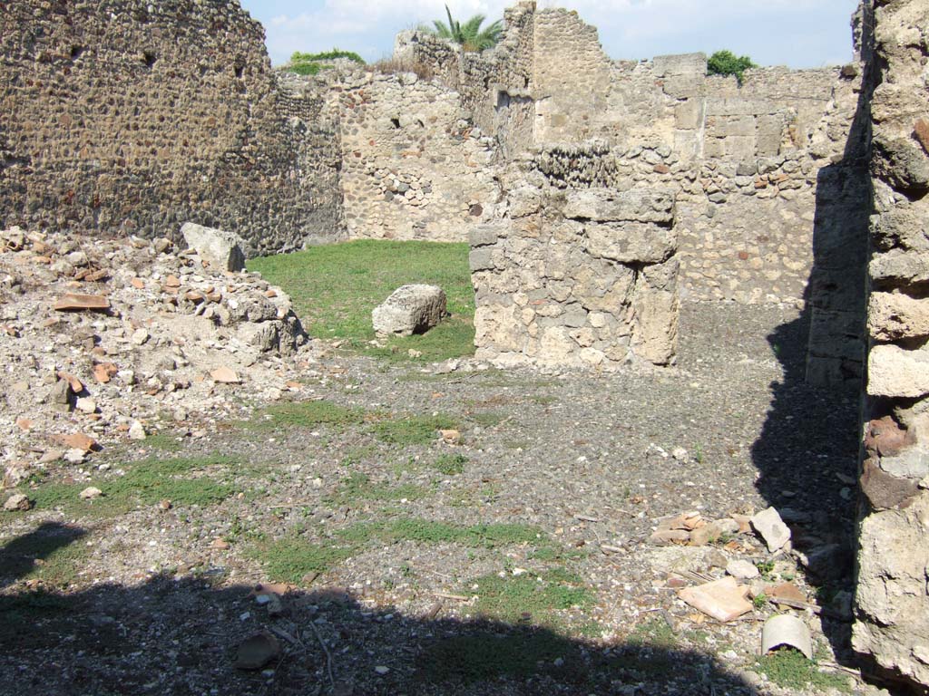 VI.11.7 Pompeii. September 2005. Looking east from entrance, on the left would have been the triclinium.
According to Fiorelli, this was a small house of only three rooms, consisting of entrance corridor, cubiculum and triclinium.
Apart from these rooms it also had a long recess, at the back in which were the hearth and the latrine.
See Pappalardo, U., 2001. La Descrizione di Pompei per Giuseppe Fiorelli (1875). Napoli: Massa Editore. (p. 69).

