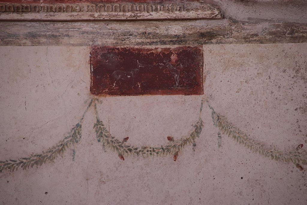 VI.15.1 Pompeii. October 2024. 
Small painted panel at north end of west wall of oecus. Photo courtesy of Klaus Heese. 
