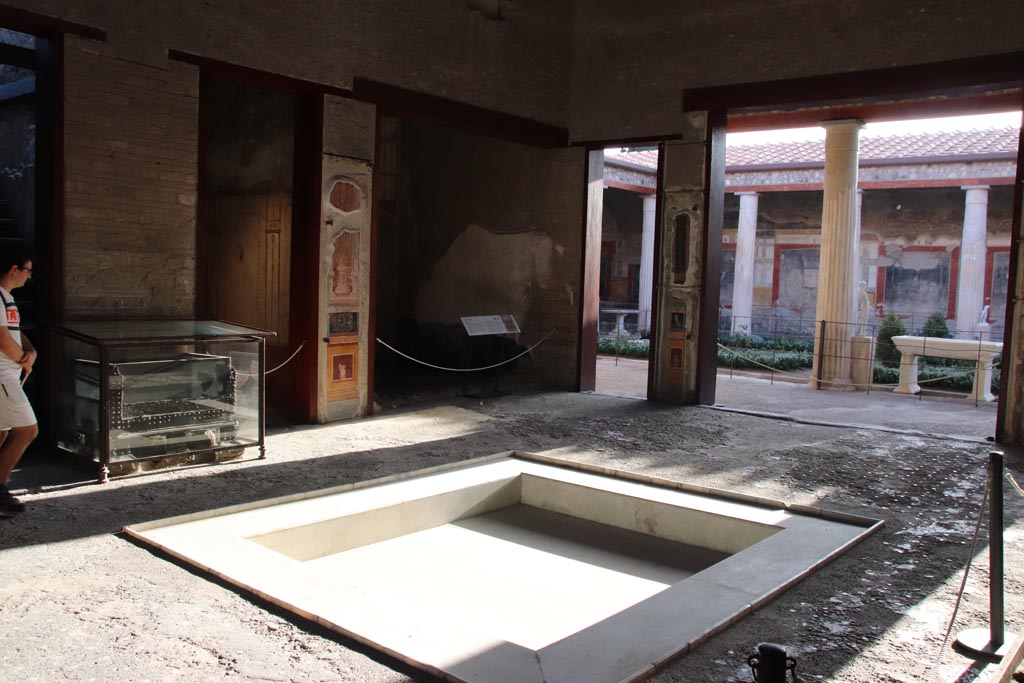 VI.15.1 Pompeii. October 2023. 
Looking south-west across impluvium in atrium, towards south ala h, in centre. Photo courtesy of Klaus Heese.
