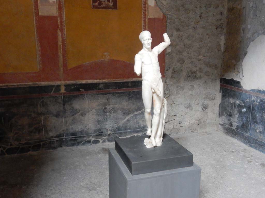 VI.15.1 Pompeii. June 2019. Statue of Priapus on display in south ala.
The flooring of the ala was made from lava-pesta containing rows of small white tesserae. Photo courtesy of Buzz Ferebee.
Originally the remains of the Priapus statue were found in the kitchen, see the pictures from 2006 and 2001 in VI.15.1 “Service”.
