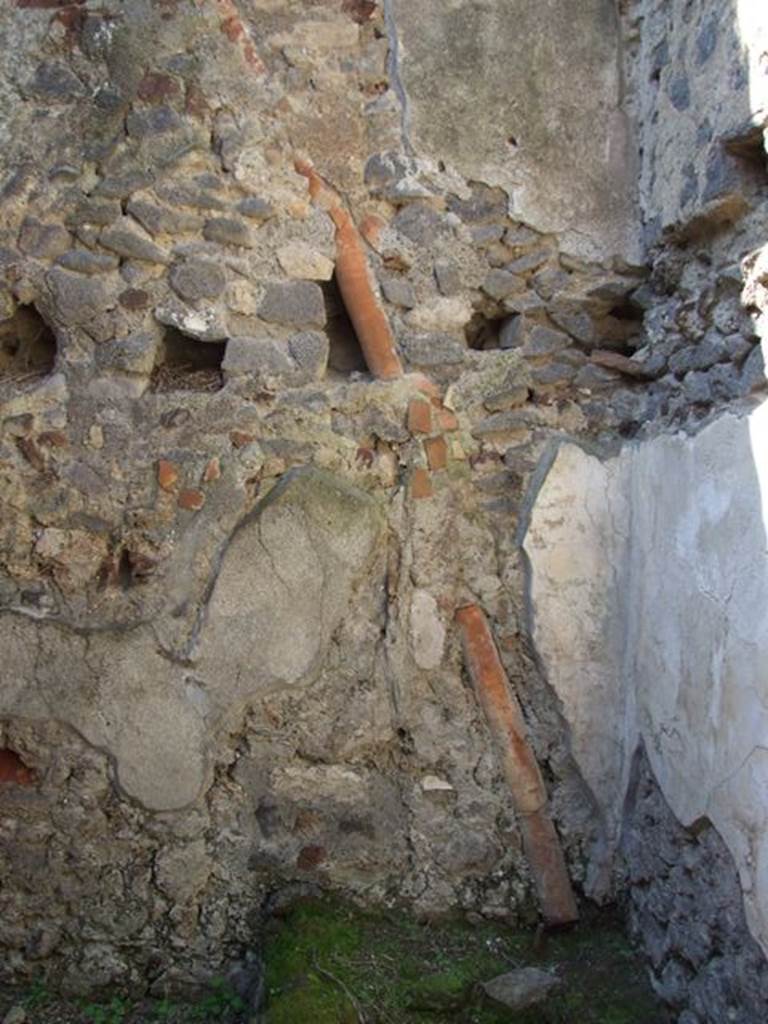 VI.15.9 Pompeii.  March 2009.  Kitchen and Latrine.  West wall, downpipe, and holes in wall for upper floor support.  