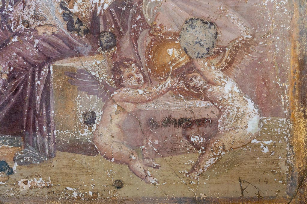 VI.16.15 Pompeii. January 2024. 
Room G, detail of Cupids playing with helmet of Mars, from central painting on north wall. Photo courtesy of Johannes Eber.
