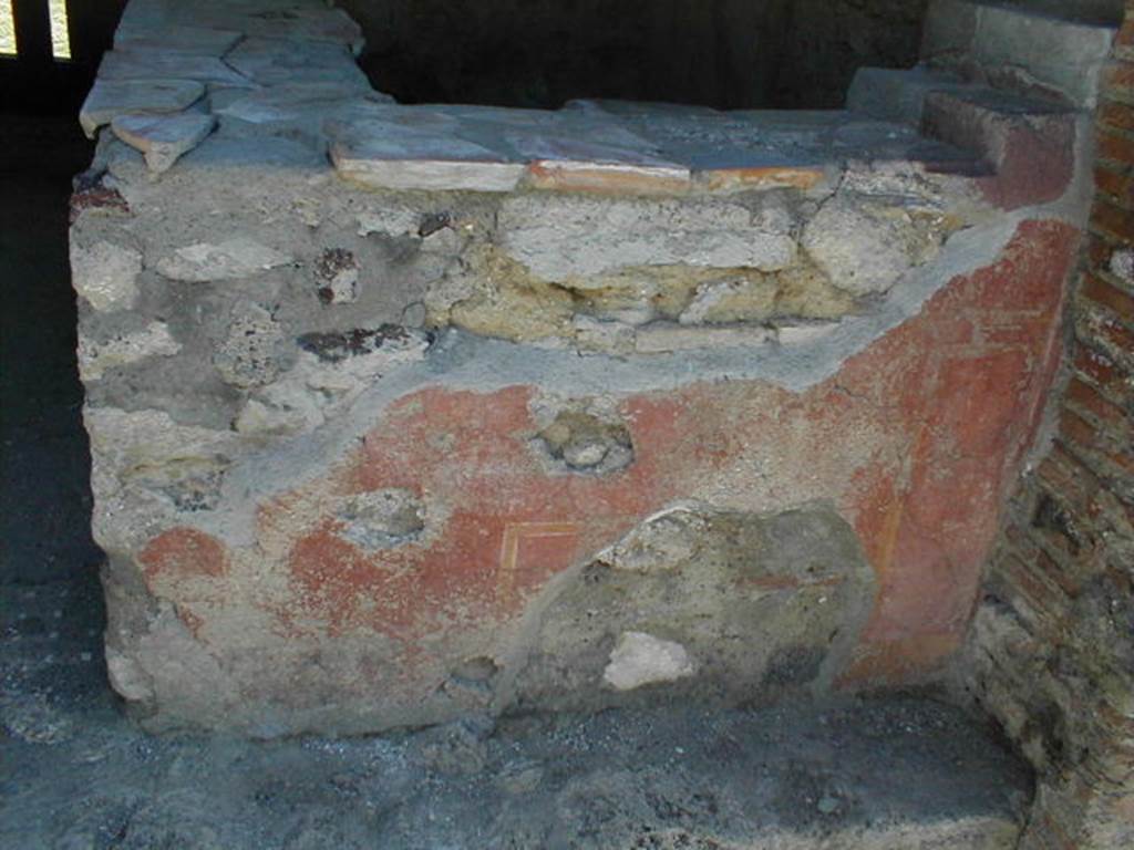 VI.16.33 Pompeii. December 2007. South wall, with display shelving and remains of painted plaster.