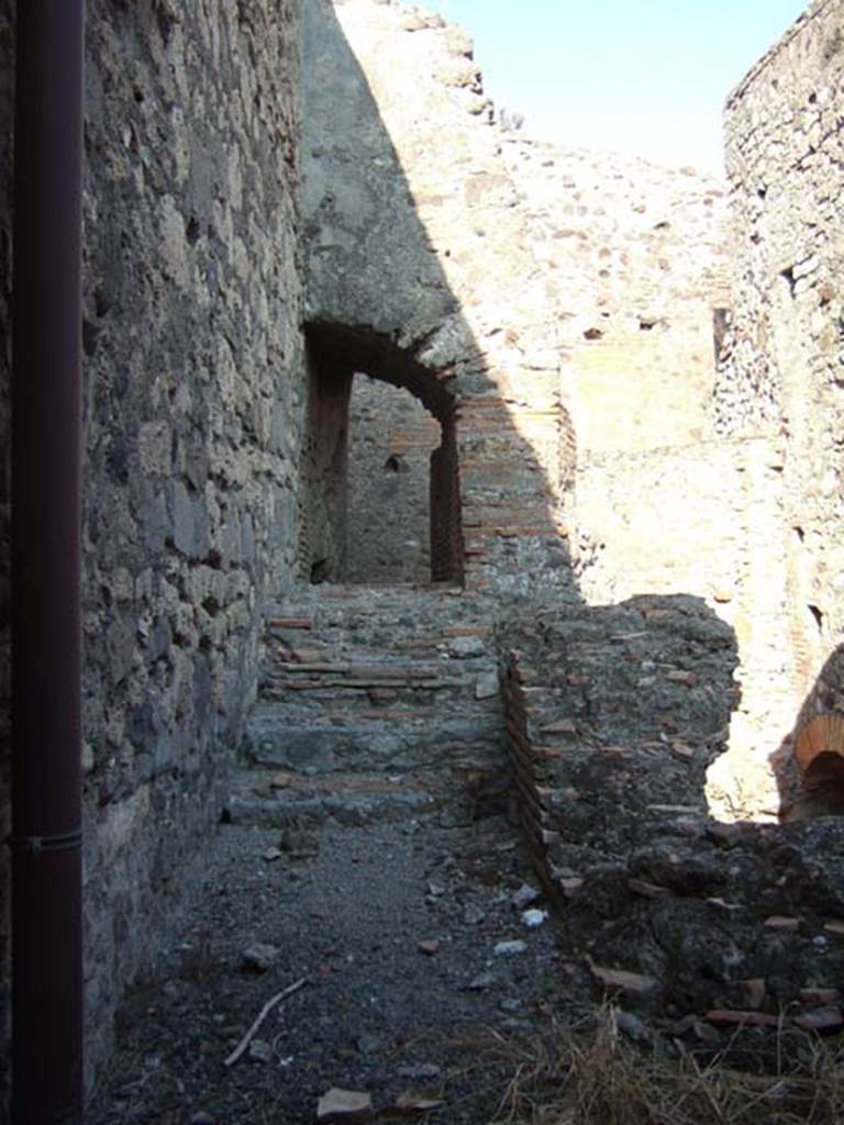 VII.1.8 Pompeii. September 2005. 
Praefurnium 7 with steps to water tanks 6 and entrance VII.1.15 through arch. 
