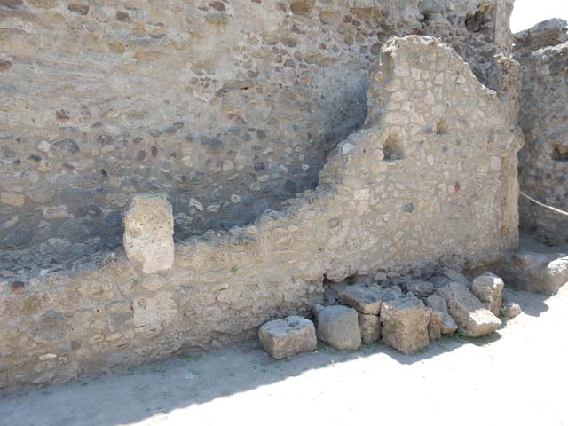 VII.1.47 Pompeii. May 2017. East end of south wall of room 21.
Behind the low wall is a narrow passage that contains a lead pipe.
The entrance corridor of VII.1.18 can be seen on the left.
The end of the narrow passage therefore probably shares the same wall as the end of the VII.1.17 corridor.
The lead pipes in the narrow passage may therefore join up with the pipe in VII.1.17.
The narrow passage may be part of VII.1.17 and the Stabian Baths.
Photo courtesy of Buzz Ferebee.

