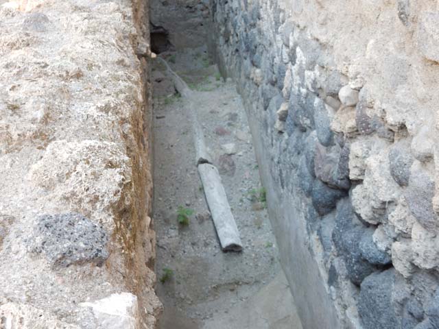 VII.1.47 Pompeii. May 2017. Detail of lead pipe in narrow passage at side of room 21.
Photo courtesy of Buzz Ferebee.
