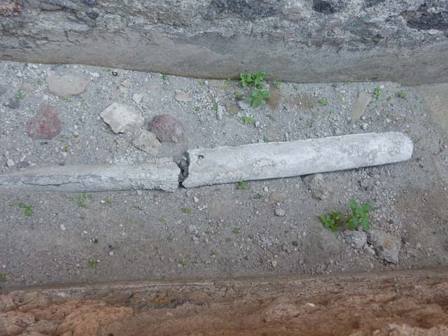 VII.1.47 Pompeii. May 2017. Other end of lead pipe behind low wall of room 21, probably part of VI.1.17.
A similar pipe can be seen on the floor of the corridor from the Stabian Baths entrance at VII.1.17.
The World of Pompeii CD plan of Pompeii shows this L shaped area as blocked off at the ends and not connected to either VII.1.47 or VII.18/17.
The PPM plan shows the L shaped area as connected to VII.1.17 and room 20 of VII.1.47.
Photo courtesy of Buzz Ferebee.

