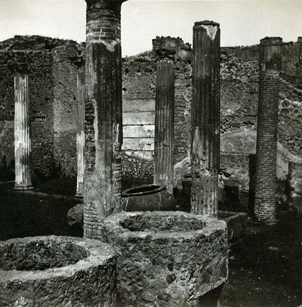 VII.2.11 Pompeii. 1912. Looking north-west across masonry towards north wall of peristyle.
At the time of excavation, in a recess of the north wall, several wooden shelves were fixed into the wall on which were found glass containers with the colours necessary for the activities of the dyers. 
Photo by Esther Boise Van Deman (c) American Academy in Rome. VD_Archive_Ph_238.
