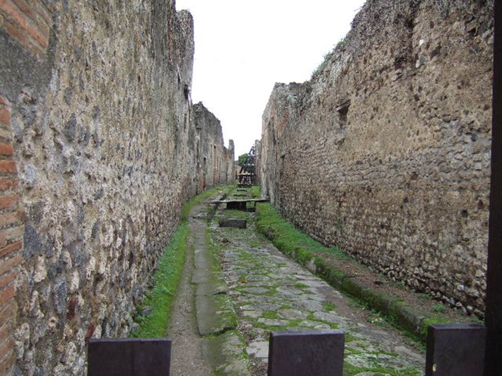 Pompeii. December 2005. Side wall of VII.2.15, (on left) looking west along Vicolo del Panettiere. 