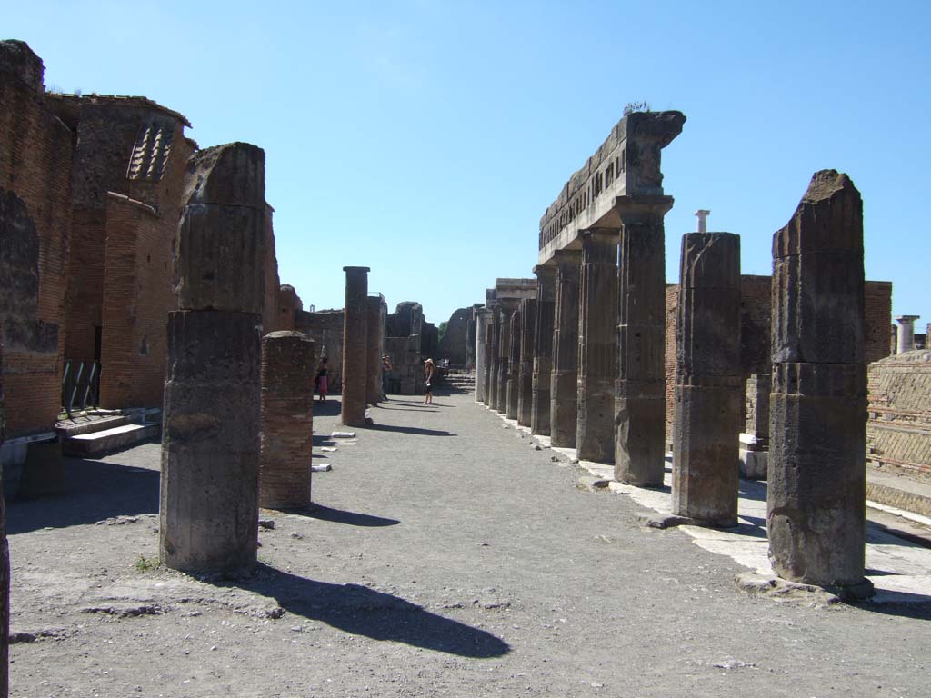 VII.8 Pompeii Forum. September 2005. South side, looking west. The double row of columns formed the colonnade of Popidius.
According to John Dobbins this was probably constructed under Roman oversight in the early years of the Sullan period, 89-80 BC.
In the 1899 English version by Mau, it states:
Near the southeast corner an inscription was found: 
V[ibius] Popidius Ep[idii] f[ilius] q[aestor] porticus faciendas coeravit
'Vibius Popidius, the son of Epidius, when quaestor caused this colonnade to be erected.'
See Mau, A., 1899, translated by Kelsey, F. W., Pompeii: Its Life and Art. New York: Macmillan. (p. 50).

In the 1908, German version, it says “south-west corner”. 
“V. Popidius Ep. f. q. porticus faciendas coeravit, so lautet eine in der Nähe der Südwestecke gefundene Inschrift.“
See Mau, A., 1908. Pompeji in Leben und Kunst, Leipzig: Engelmann, (p. 47.)

The Naples museum information card for the plaque says “Pompeii, from the area in front of the Basilica (1814)”.

