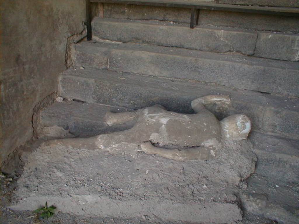 VII.16.17-22 Pompeii.  May 2006.  Plaster cast of body lying at foot of staircase.
