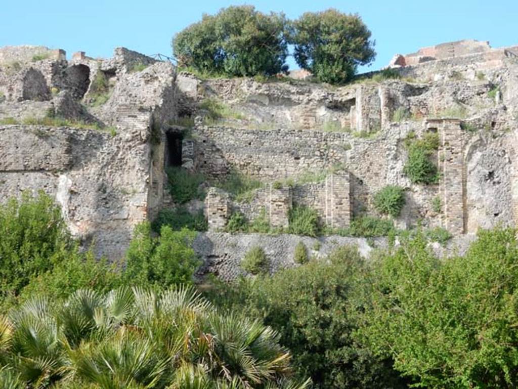 VIII.2.16 Pompeii. May 2015. 
Looking north towards lower floor levels beneath area of collapsed terrace garden. Photo courtesy of Buzz Ferebee.

According to Boyce, in a kind of cave beneath the court located behind the large atrium of number 16, on the extreme edge of the slope was a sacrarium of peculiar nature.
Against the rear wall of a narrow passage was built a masonry seat.
In the wall above it, a vaulted opening led into a small cell hewn out of the rock, with its floor 0.50m below that of the outer passage.
A second masonry seat was built within the cell, back to back with that in the outer passage.
The only means of entrance into this inner chamber appeared to have been over these two seats and through the small opening above them.
Within the cella stood a rectangular masonry altar and upon the altar lay a small terracotta altar, a marble ball, and two lamps decorated with reliefs.
One of the lamps was decorated with the relief of Jupiter, the other of a rose.
See Notizie degli Scavi di Antichità, 1890, 290.
See Boyce G. K., 1937. Corpus of the Lararia of Pompeii. Rome: MAAR 14. (p.74, no.344) 
See Giacobello, F., 2008. Larari Pompeiani: Iconografia e culto dei Lari in ambito domestico. Milano: LED Edizioni. (p.246)

