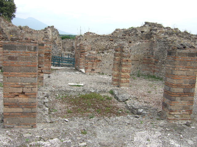 VIII.2.29 Pompeii. September 2005.  Looking north across tablinum to atrium and entrance doorway. In the north-west corner of the atrium would have been a masonry lararium, (in the area to the left of the brick pilasters). According to Boyce, this lararium was later in date than the stucco of the walls of the room. The walls were in the IVth Style.
Around the base of the lararium ran a dado of marble. In this corner of the atrium the black border in the mosaic pavement was made to run around the two sides of the podium. This marked its position.
According to Mau, some other object stood here before the construction of the lararium. These would have been either the arca for the money, or a smaller and more modest lararium, which was then enlarged.
Not. Scavi, 1883, 135. Bull. Inst, 1885, pp.88, 93.
See Boyce G. K., 1937. Corpus of the Lararia of Pompeii. Rome: MAAR 14. (p.74, no. 346) 
According to Giacobello, only the podium survives of the aedicula in the north-west corner of the atrium.
See Giacobello, F., 2008. Larari Pompeiani: Iconografia e culto dei Lari in ambito domestico.  Milano: LED Edizioni. (p.247)
