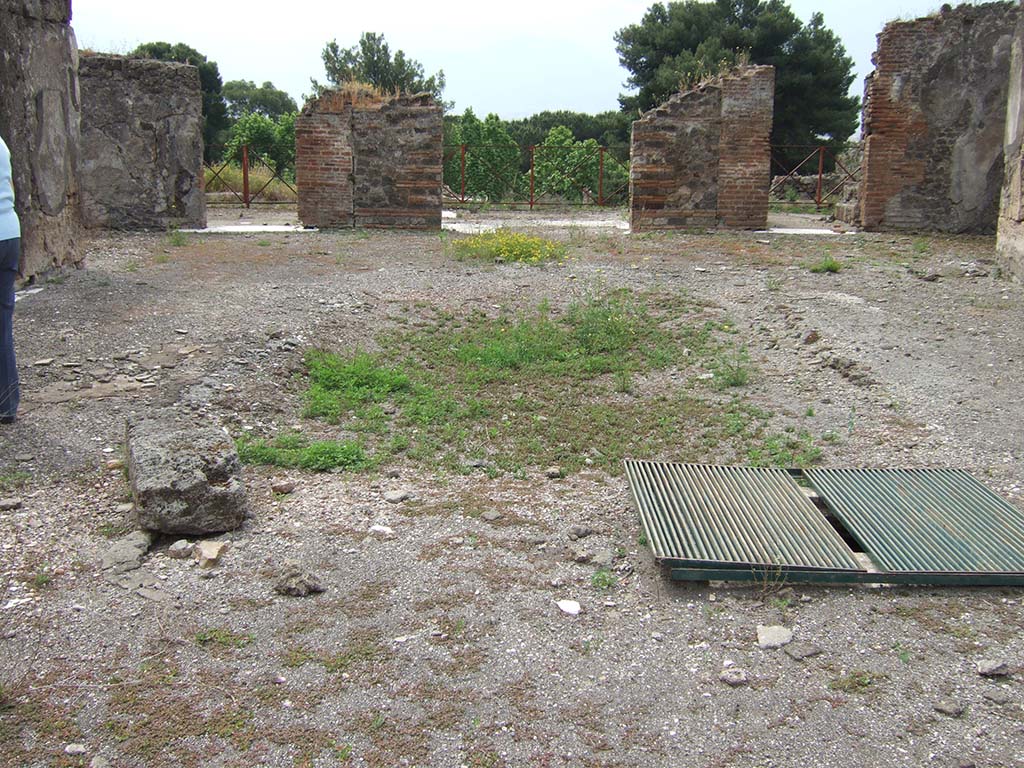 VIII.2.34 Pompeii. May 2006. Doorway to cubiculum ‘f’, in centre of east side of atrium.
The floor in this room was identical to room ‘e’, being of cocciopesto with dots of small white tesserae in regular lines.
The east wall can be seen through the doorway, with red zoccolo which had painted plants in panels separated from a central panel.
The middle zone of the wall would have been white.

