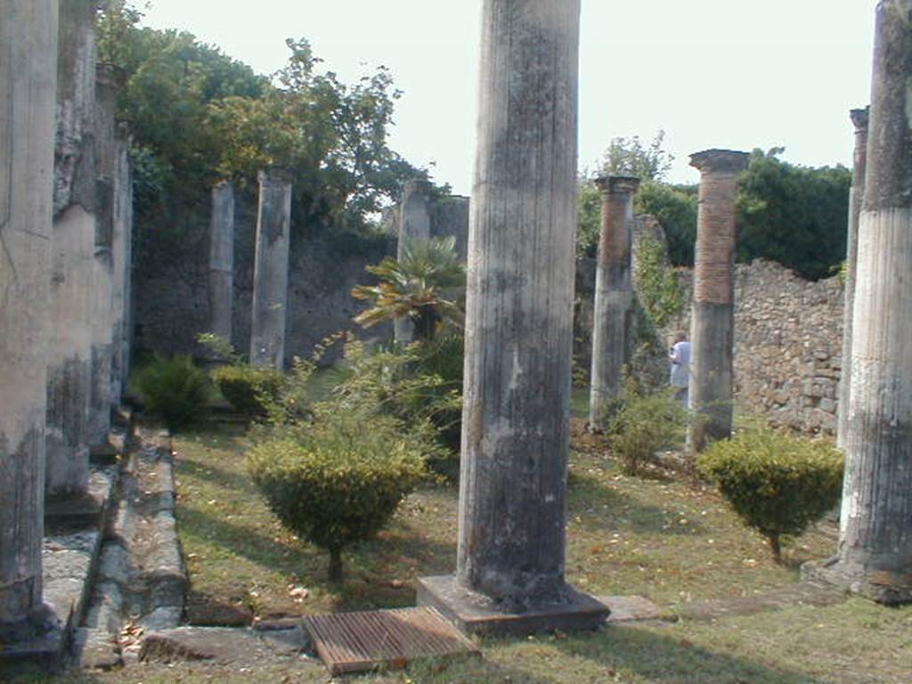 VIII.3.8 Pompeii. September 2004. Peristyle, looking south towards the large exedra.
According to Breton - 
two columns were placed on pedestals decorating the entrance to the oecus, where the mosaic paving has only preserved a few remains of the beautiful greek white, black, red and yellow that surrounded it.
See Breton, Ernest. 1870. Pompeia, Guide de visite a Pompei, 3rd ed. Paris, Guerin, (p.453).


