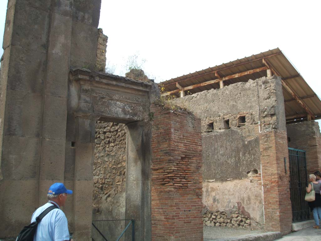 VIII.3.10 and VIII.3.9 Pompeii. September 2004. Looking south-west on Via dell’Abbondanza.
According to Della Corte, he thought the seat of the Collegium Aurificum may have been on the upper floor of VIII.3.9.
He deduced this by an electoral recommendation, mutual to all the neighbours, that was on the opposite external wall of the Building of Eumachia. 
This read -
Aurifices universi rog(ant)  [CIL IV 710]
From this graffito, Della Corte states the name of the “Via degli Orefici” was given to the street in some of the old bibliographies.
See Della Corte, M., 1965. Case ed Abitanti di Pompei. Napoli: Fausto Fiorentino. (p.229)

According to Epigraphik-Datenbank Clauss/Slaby (See www.manfredclauss.de) the graffito read as -

C(aium)  Cuspium  Pansam  aed(ilem) 
aurifices  universi 
rog(ant)         [CIL IV 710] 
