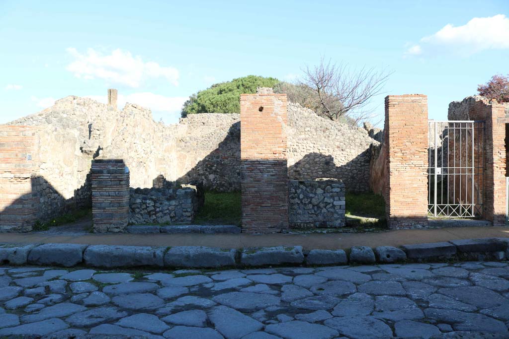 VIII.3.24 Pompeii, on left, VIII.3.23, VIII.3.22, and VIII.3.21, on right. December 2018.  
Looking east to entrance doorways from Via delle Scuole. Photo courtesy of Aude Durand.

