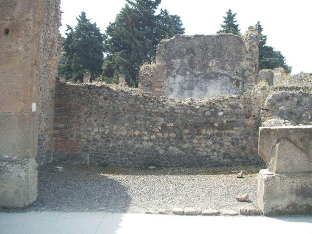 VIII.5.27 Pompeii. May 2005. Looking south at entrance to shop.
On the right at the rear would have been the steps to the upper floor, the base of them can just be seen. The remains of the downpipe from upper floor can also be seen in the wall in the south-west corner (on the right).

