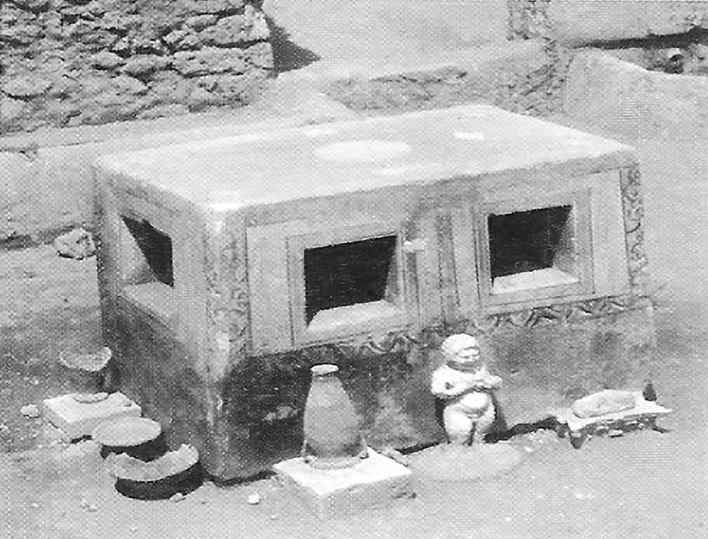 VIII.7.10 Pompeii. 1910. Detail of unusual masonry table to north of triclinium, with amphora, statuette and other objects.
According to PARP: PS (2005), this table is now totally destroyed.
See PARP: PS 2005 season report http://www.fastionline.org/docs/FOLDER-it-2005-48.pdf . (p. 3)
See Notizie degli Scavi di Antichità, 1910, p. 265-7, fig. 6.
