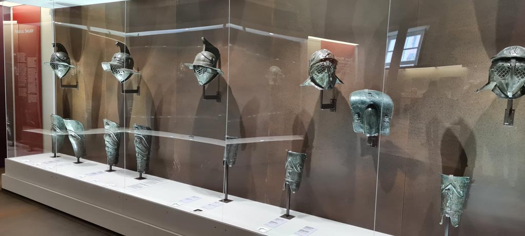 Naples Archaeological Museum, display case with helmets, galerus and greaves. Photo taken May 2021. Photo courtesy of Giuseppe Ciaramella.