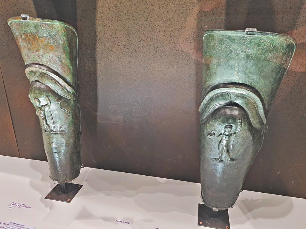 VIII.7.16 Pompeii. 
Pair of bronze leggings or Gladiator’s Greaves found in the barracks. 
On left - Bronze Greave with depiction of Jupiter, inv. 5645.
On right – Bronze Greave with depiction of Neptune, inv. 5647
Photo taken May 2021, courtesy of Giuseppe Ciaramella.


