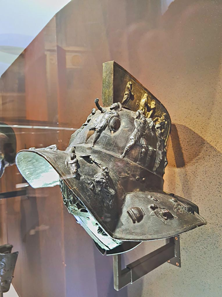 VIII.7.16 Pompeii. Photo taken May 2021, in Naples Archaeological Museum, inv. 5673.
Murmillo’s helmet with scenes of capture of Troy, discovered Pompeii on 23rd May 1767 in Gladiator’s Barracks. 
(Side 2). Photo courtesy of Giuseppe Ciaramella.


