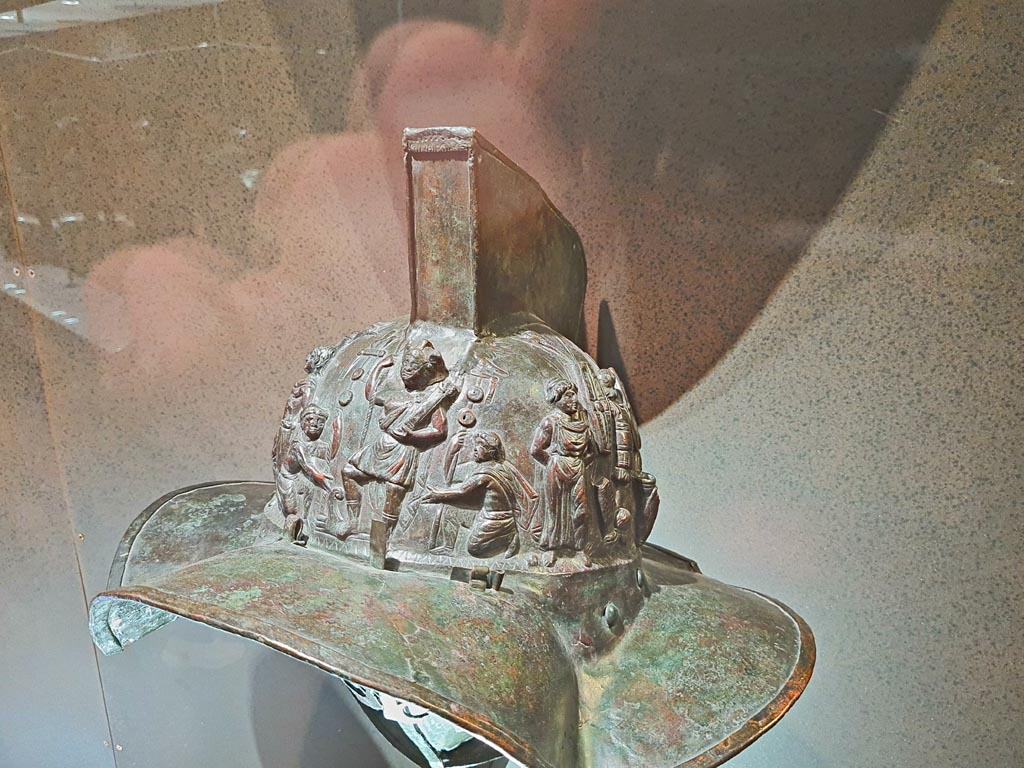VIII.7.16 Pompeii. Photo taken May 2021, in Naples Archaeological Museum, inv. 5674.
Murmillo gladiator’s helmet, with personification of Rome, Barbarian captives, trophies and Victories. 
(Side 1- detail). Photo courtesy of Giuseppe Ciaramella.

