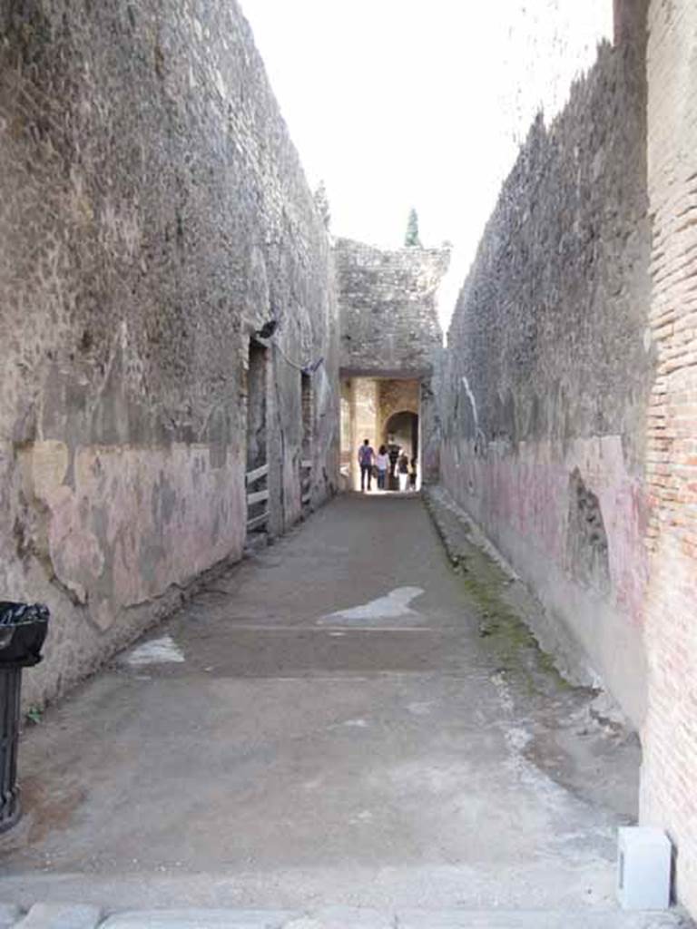 VIII.7.20 Pompeii. September 2010. Entrance passage or Graffito passage.
Passage looking west towards large theatre, Little Theatre or Odeon to left of image.
Photo courtesy of Drew Baker.

According to Gell, this passage was known as “the great passage” – “This passage is full of inscriptions, scratched with nails and knives by people waiting for admittance. Amongst them is an  
These were, of course, not always regulated by the strictest rules of propriety. They are very faint, and every day become less visible.
See Gell, W. and Gandy, J., 1852.  Pompeiana: Third Edition.  London: Bohn. (p.183)

This passage is often called the "Graffito Passage" because of many graffiti found on the walls.
Fiorelli quoted 3 of the most complete as being the following -
the first was written in one single line on the south side of the corridor in the theatre complex: 
    Methe Cominiaes(!) atellana amat Chrestum corde [si]t utreisque Venus Pompeiana propitia et sem[per] concordes veivant    [CIL IV 2457]
    Varone translates this as “Methe of Atella, slave of Cominia, loves Chrestus. May Venus of Pompeii smile favourably on their hearts and let them always live in harmony”.
    See Varone, A., 2002. Erotica Pompeiana: Love Inscriptions on the Walls of Pompeii, Rome: L’erma di Bretschneider. p.164.
the second was 
    A(nte) d(iem) VI Novembres praebuit Surus Petilius ornamenta / M(arco) [Faust]o Siloni honoris causa Suri liberti     [CIL IV 2455]
the third which he says in 1875 “was recently taken to Naples Museum” was
    A(nte) d(iem) XI K(alendas) Decembr(es) a(ssibus) XV 
    Epap(h)ra Acutus Auctus 
    ad locum duxserunt(!) 
    mulierem Tychen pretium
    in singulos a(ssibus) V f(uit?)
    M(arco) Messalla L(ucio) Lentulo co(n)s(ulibus)     [CIL IV 2450]
See Pappalardo, U., 2001. La Descrizione di Pompei per Giuseppe Fiorelli (1875). Napoli: Massa Editore. p.133 [354]

Varone translated an inscription on the north wall of the corridor as:
    I’m hurrying to you! Hello, my Sava. Try and love me.
    Propero vale mea sava / fac me ames    [CIL IV 2414]
See Varone, A., 2002. Erotica Pompeiana: Love Inscriptions on the Walls of Pompeii, Rome: L’erma di Bretschneider. p. 40.

There were many more inscriptions, in all summed up by one quoted by Fiorelli:
    AD MIROR PARIIIS
    RVi NA 
    TII NON CIICIDISII

    Admiror paries / te non cecedis(s)e / ruina    [CIL IV 2461]
See Pappalardo, U., 2001. La Descrizione di Pompei per Giuseppe Fiorelli (1875). Napoli: Massa Editore. p.134 [356].

Jacobelli translated this as, 
    “It is a wonder O wall that you haven’t collapsed under the weight of such nonsense”.
    See Jacobelli, L., 2003. Gladiators at Pompeii. Rome: L’Erma di Bretschneider.  p. 41.
Similar inscriptions were also found on two other walls, CIL IV 2487 from the ampitheatre, and CIL IV 1904 from the Basilica.
