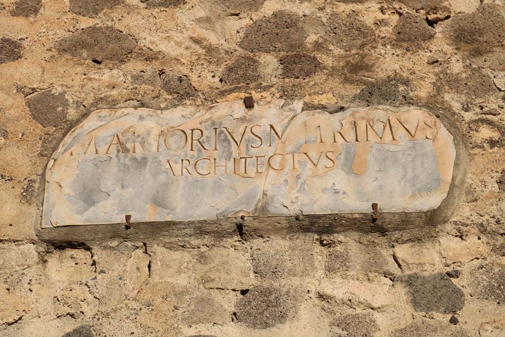 VIII.7.21 Pompeii. December 2018. Reproduction plaque on wall between theatres. Photo courtesy of Aude Durand.
The text on the original white marble slab (inv. 3834) provides the name of the architect involved in the refurbishment of the theatre –
M. Artorius Primus, freedman of Marcus. 
The original plaque is now on display in the Campania Romana gallery of the Naples Archaeological Museum. 
Also see VIII.7.20 Pompeii.


