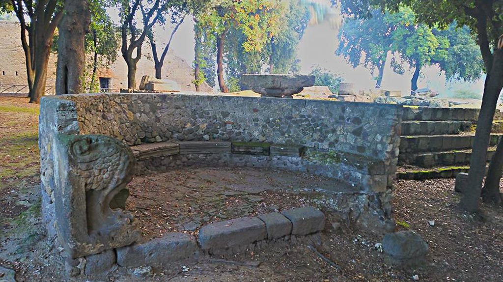 VIII.7.33 Pompeii. 2015/2016. 
Semi-circular stone bench or schola with lions’ feet next to the south-west corner of the temple. Photo courtesy of Giuseppe Ciaramella.
