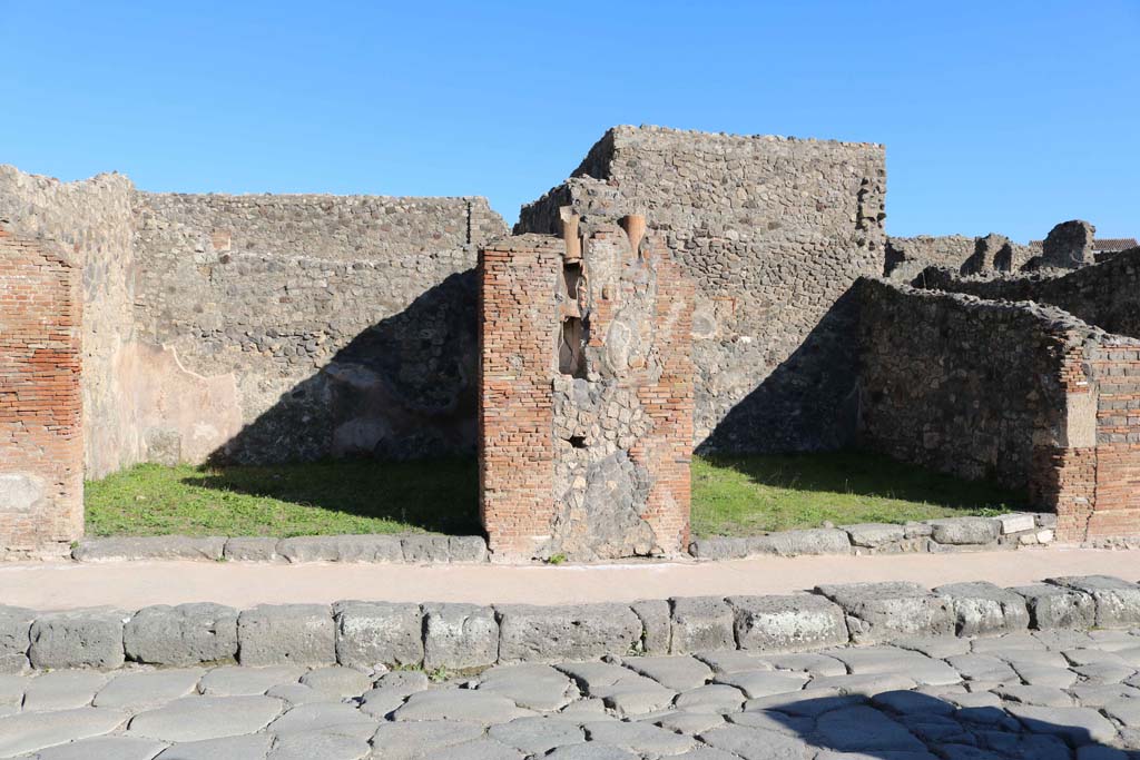 IX.2.2 Pompeii, on left, and IX.2.3, on right. December 2018. 
Looking east to entrance doorways on Via Stabiana with downpipe between. Photo courtesy of Aude Durand.
