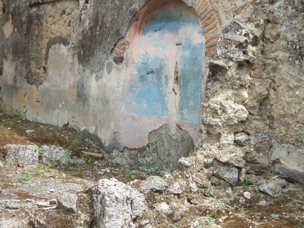 IX.2.7 Pompeii. May 2006. Arched niche painted blue in wall at rear of the pool. This had a painting of a nymph who held in her hands a crater-shaped fountain from which water fell.   The painted water was continued by a jet of real water which splashed into the pool.
See Jashemski, W. F., 1993. The Gardens of Pompeii, Volume II: Appendices. New York: Caratzas. (p.228).
