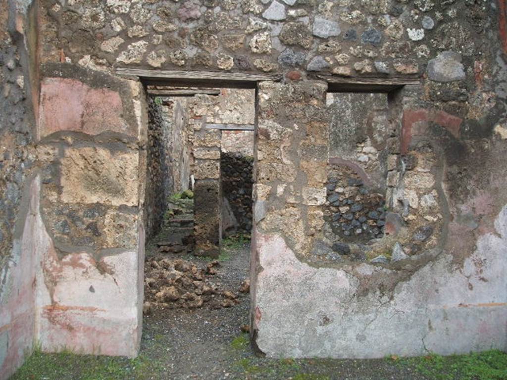 IX.2.12 Pompeii. December 2004. East wall of shop, with doorway to rear rooms.