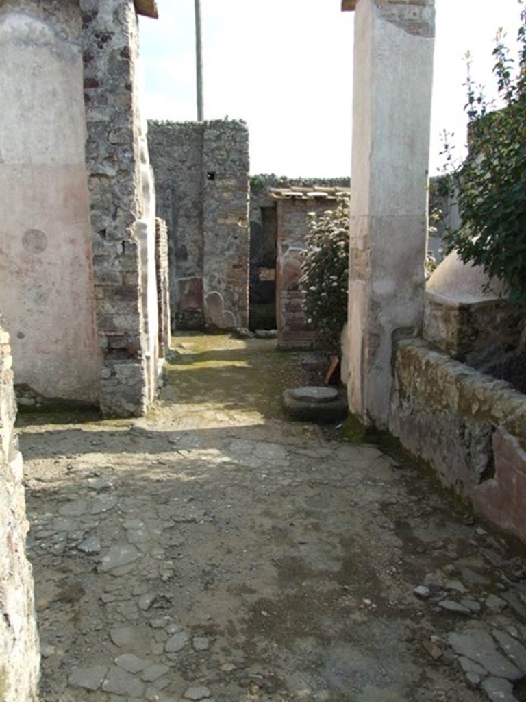 IX.3.5 Pompeii. March 2009. Room 21, corridor, looking south. Large doorway to room 20, on left.  According to Dyer: “The peristyle is surrounded on two of its sides with square columns, painted with plants on a red background. The pillars are connected together by a low wall, which leaves two openings into the xystus, or garden. On the other sides it is bounded by the tablinum in front, and by an exedra or oecus, on the right (of the peristyle)”.
See Dyer, T., 1867. The Ruins of Pompeii. London: Bell and Daldy. (p.85)
