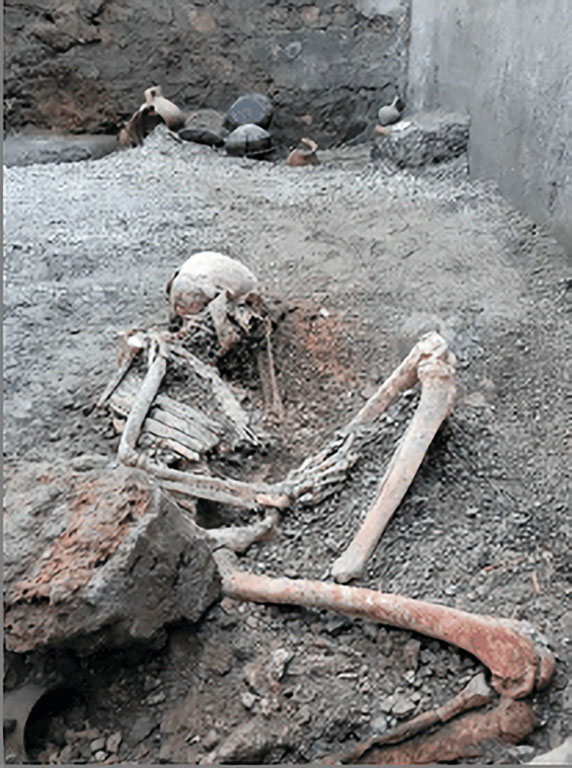 IX.12.B/IX.12.9 Pompeii. May 2023. Room “a”, skeleton of victim 2 in the south-east corner.
Scheletro della vittima 2 nell'angolo sud-est.
Photograph © Parco Archeologico di Pompei.


