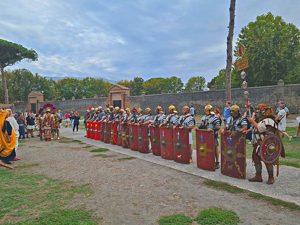 II.7.3 Pompeii, on left, II.7.4 in centre. September 2024. Legionaries on parade.
Looking south-west on Piazzale Anfiteatro towards Palaestra during “Ludi Pompeiani” event. Photo courtesy of Giuseppe Ciaramella.

