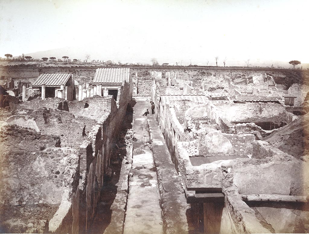 Unnamed vicolo between IX.8 and IX.9. C.1890? Photo by Sommer numbered 1298. 
Looking north from south end with work ongoing in the pavement of the street.
On the left is IX.8.8, on the right is the balcony of IX.9.f. Photo courtesy of Espen B. Andersson.

