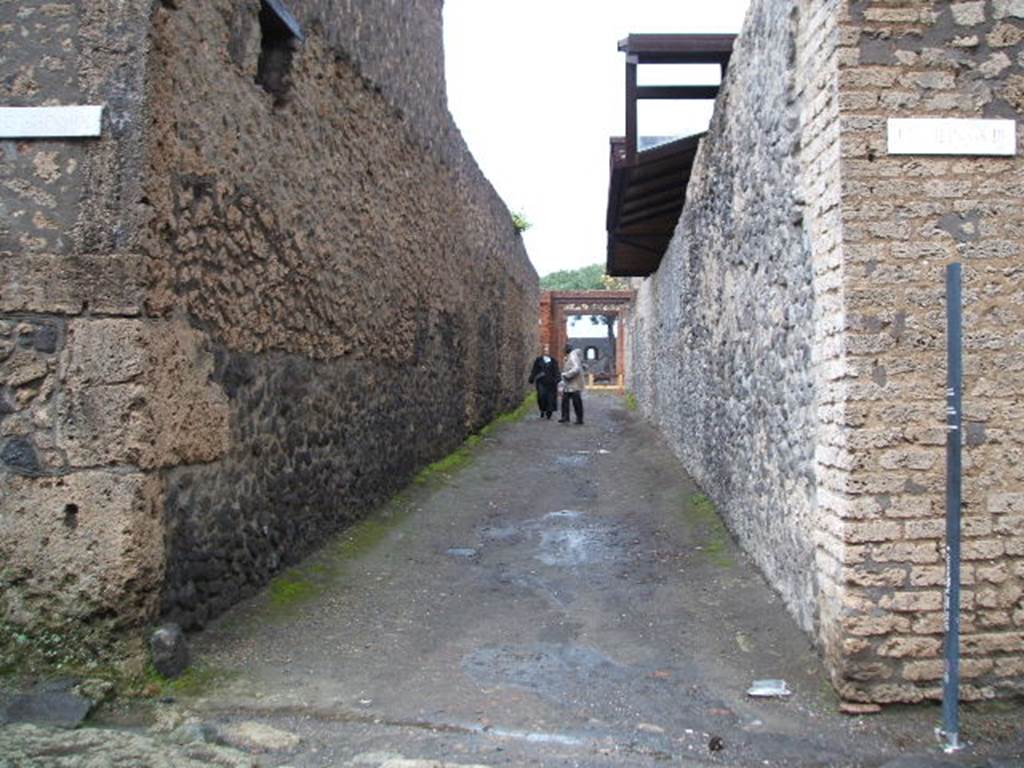 Via di Nocera, east side, December 2004. Looking east between II.9 and II.8, from the junction with Via della Palestra. 