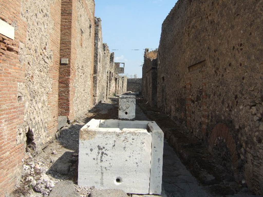 Vicolo del Gallo between VII.15 and VII.7. Looking east from junction with Vicolo del Gigante, showing fountain in middle of the vicolo. September 2005.