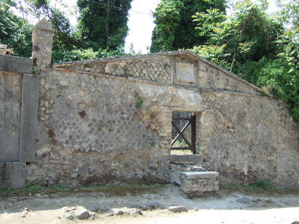 HGW23 Pompeii. May 2006. Front and entrance, looking west.
According to Soprano –
It was the only funeral triclinium so far found in Pompeii. It is located in a small open space which can be accessed from the via dei Sepolcri. The entrance door, m. 1.23 and wide m. 1.05, was surmounted by a pediment with inscriptions that make known the name of the builder of the triclinium, the freedman Callisto, and the person to whom it was dedicated; Cn. Vibio Saturnino.
See Soprano, P. 1950. I triclini all’aperto di Pompei. (In Pompeiana, raccolta di studi per il secondo centenario degli scavi di Pompei. Napoli, Gaetano Macchiaroli, Editore, p.304, no.21.
In April 1790 the inscription GABINIG…. was found on the wall to the right of the entrance [CIL IV 87].
See Kockel V., 1983. Die Grabbauten vor dem Herkulaner Tor in Pompeji. Mainz: von Zabern. (p. 109).
From PAH, addendum, p.133 – 
La Vega 99. In April 1790 a ditch was made at the marked location because of rain water, and on the wall there were the following characters, 2 ¼ Pal high, and which later by the ancients had been whitewashed, and they are GABINIG ....... The ditch was filled, and the inscription remains where it was seen.
See Fiorelli G., 1860. Pompeianarum antiquitatum historia, Vol. 1: 1748 - 1818, Naples, addendum p. 133.
