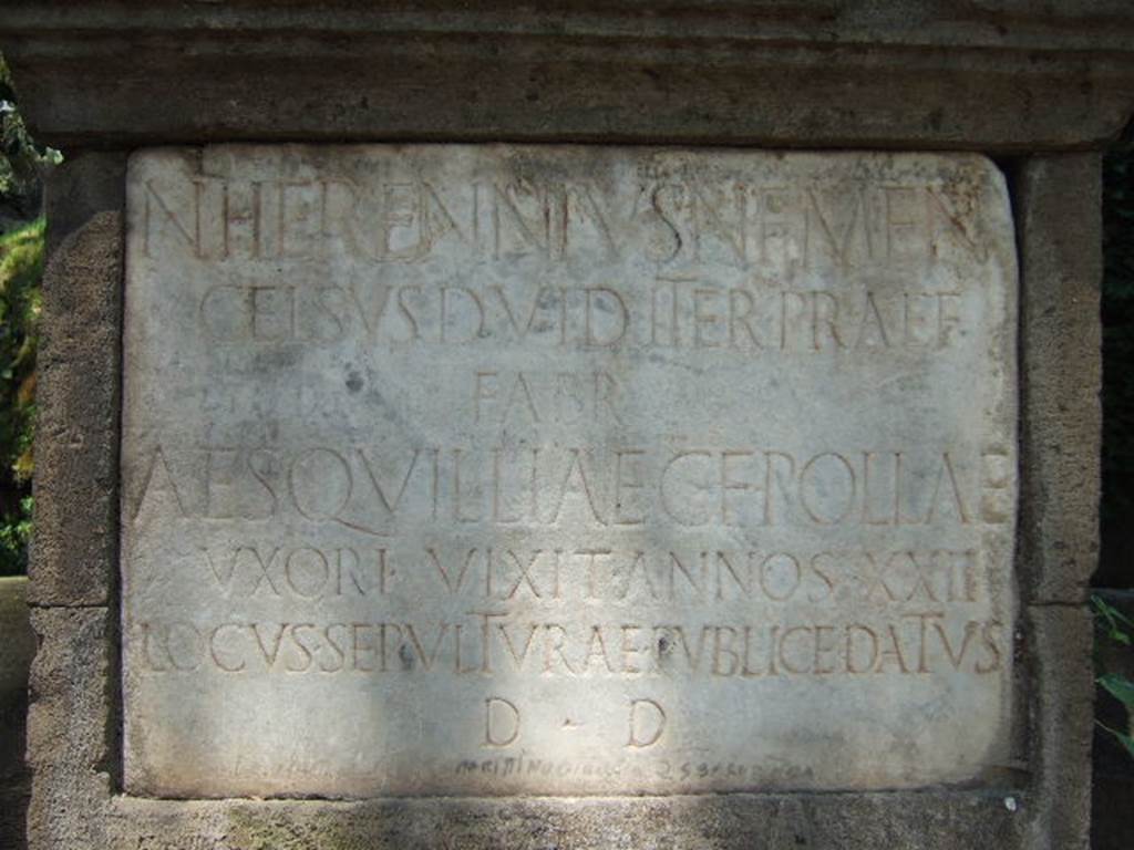 NGG Pompeii. May 2006. Inscription on marble plaque of tomb of Aesquillia Polla.
N(umerius) HERENNIVS N(umeri) F(ilius) MEN(enia) 
CELSVS D(uovir) I(ure) D(icundo) ITER(um) PRAEF(ectus) 
FABR(um) 
AESQVILLIAE  C(ai) F(iliae) POLLAE 
VXORI  VIXIT  ANNOS XXII
LOCVS SEPVLTVRAE PVBLICE DATVS 
D(ecreto) D(ecurionum)

According to Cooley it translates as – Numerius Herennius Celsus, son of Numerius, of the Menenian tribe, duumvir with judicial power twice, staff officer, to Aesquillia Polla, daughter of Gaius, his wife. She lived 22 years. A burial place was given publicly by decree of the town councillors. See Cooley, A. and M.G.L., 2004. Pompeii : A Sourcebook. London : Routledge. (p. 139, G5).