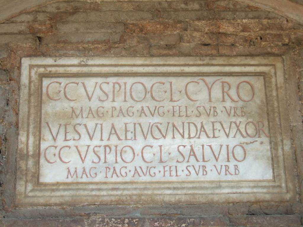 Pompeii Porta Nocera. May 2006. Tomb 17ES. Marble plaque with Latin inscription:
C(aio) CVSPIO C(ai) L(iberto) CYRO
MAG(istro) PAG(i) AVG((usti) FEL(icis) SVB VRB(anis)
VESVIAE IVCVNDAE VXOR(i)
C(aio) CVSPIO C(ai) L(iberto) SALVIO
MAG(istro) PAG(i) AUG((usti) FEL(icis) SVB VRB(anis).

Caius Cuspius Cyrus and Caius Cuspius Salvius were both freedmen of Caius Cuspius.
Vesvia Iucunda the wife of C. Cuspius Cyrus would appear also to be free.
Both men would appear to have been magistrates/priests of the Pagus Augustus Felix Suburbanus.
