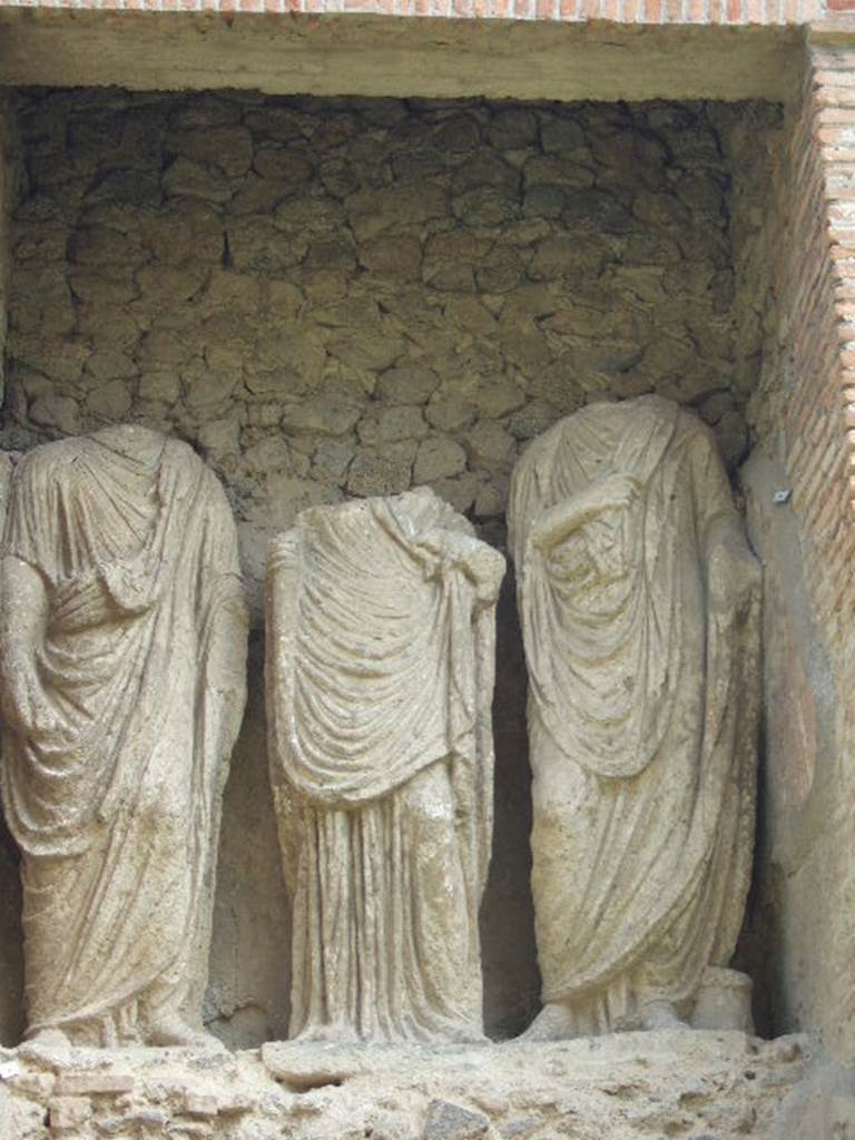 Pompeii Porta Nocera Tomb 23OS. Three headless statues. May 2006.
Publius Vesonius Phileros I, to the left wearing a toga. Vesonia, daughter of a Publius Vesonius, is in the centre wearing in tunic and mantle. Marcus Orfellius Faustus, to the right wearing a toga.
