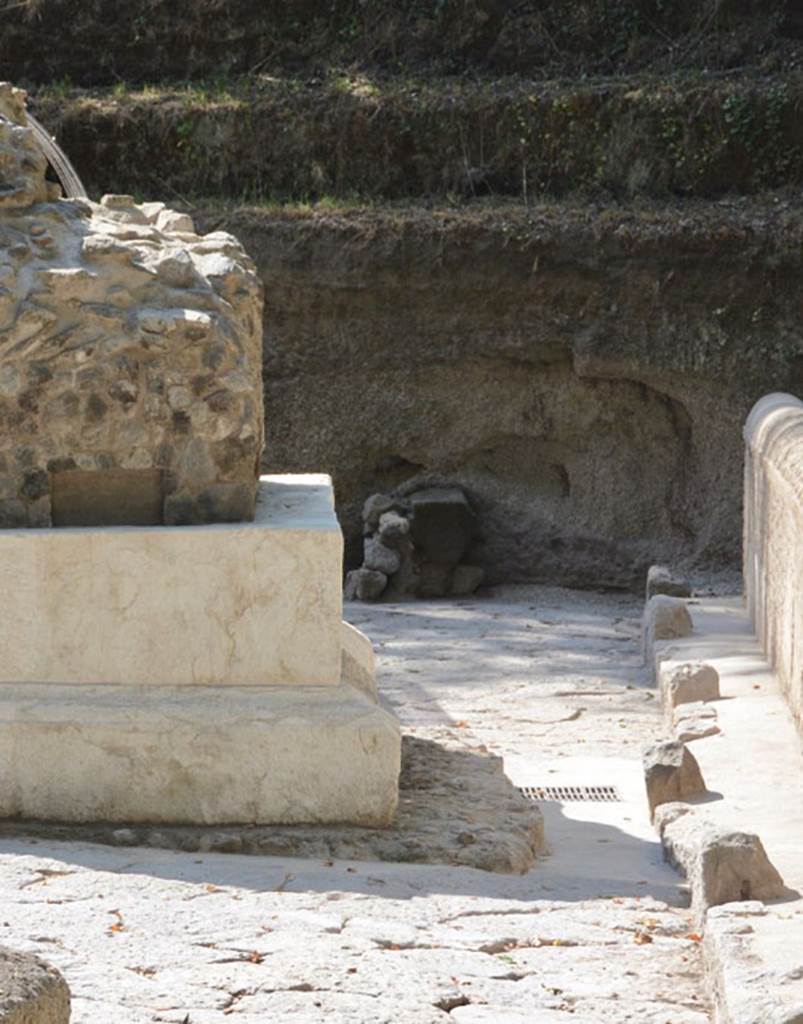 SG4 and SG5 Pompeii. 2018. Sub-square masonry structure at rear, possible third tomb? 
The removal of the thick deposit layer from the road revealed an unfinished sub-square masonry structure to the south of Tomb SG4. 
These pieces of evidence likely relate to a third tomb, which was unfinished following the abandonment of the site, as the tuff and lava blocks which were discovered in the immediate vicinity and appeared ready to be used in construction would indicate, along with a pile of lava and small block chips.
See http://pompeiisites.org/en/comunicati/the-tombs-of-the-necropolis-of-porta-stabia/
