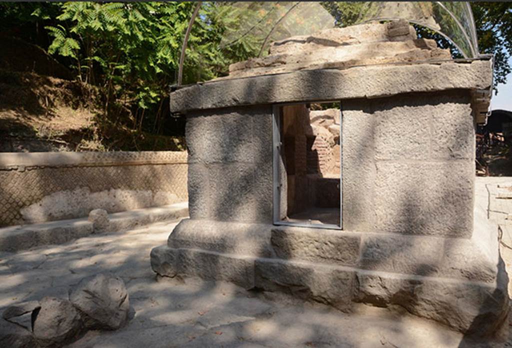 SG5 Pompeii. 2018. Entrance to tomb on side facing south away from the Stabian Gate.
The entrance to the tomb is closed by a limestone door, which features two legible tituli picti. 
The door has an iron ring on the outside, and a bronze locking system on the inside, as well as bronze hinges. 
The door was closed at the time of the excavation, and was opened for the 2017 restoration works, revealing that it still worked perfectly, 2000 years since the Roman locking mechanism was crafted. 
On the upper part of the door an inscription is present, in the form of a titulus pictus, which reports “Iarinus Expectato / ambaliter unique sal(utem) / Habito sal(utem)” “Iarinus greets Expectatus as an eternal friend; greetings to Habitus”. Above the name of Habitus, somebody drew a phallus.
See http://pompeiisites.org/en/comunicati/the-tombs-of-the-necropolis-of-porta-stabia/
