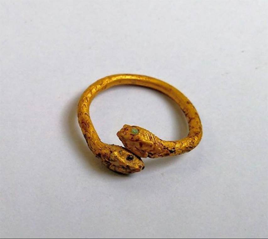 SG4 and SG5 Pompeii. 2018. Gold ring with two serpents’ heads facing, found in road by the tombs.
The paved road was in fact completely covered with a thick layer of alluvial accumulation that has yielded a large number of glass and ceramic finds such as lachrymatories and “pedine” (gaming pieces) but also a gold ring with two facing snake heads with eyes in glass paste.
See VesuvioLive.it